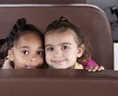 two first grade girls sitting together on a school bus