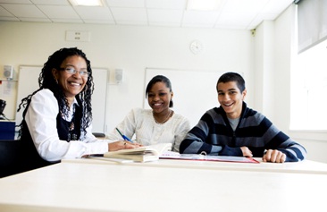 teacher and upper grade students seated at table