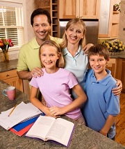 smiling home school family with books open at the kitchen counter