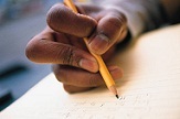 student's hand, writing on his paper